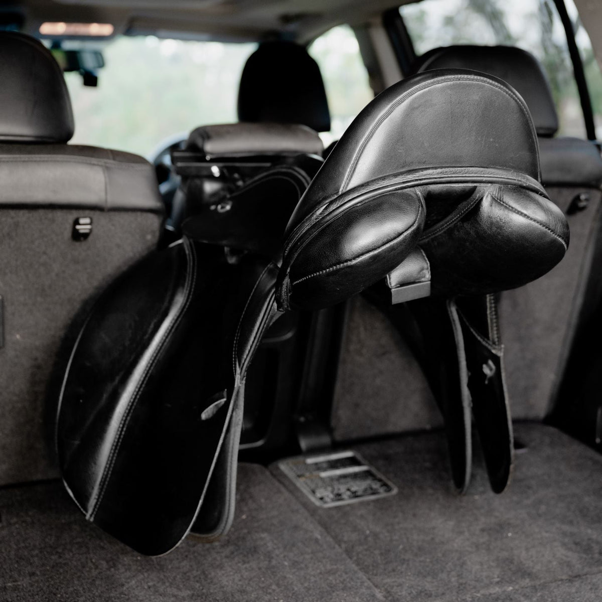 Lumiere Car Saddle Caddy - saddle sitting on the caddy in a car boot
