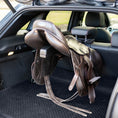 Load image into Gallery viewer, Lumiere Car Saddle Caddy - brown saddle carried on the caddy with the boot open
