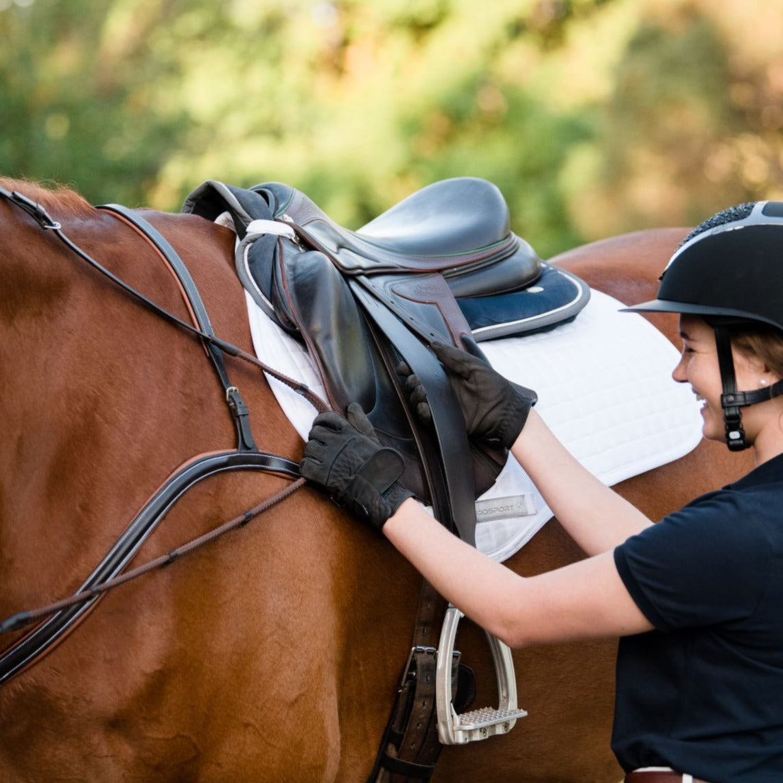 Lumiere Stirrup Leathers Jumping Stability (Standard 140cm) - rider adjusting the leathers on a saddled horse